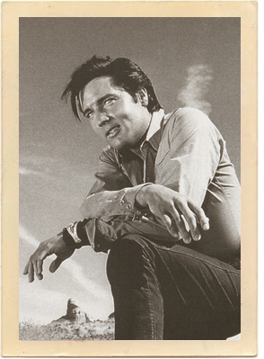 The gorgeous, world-famous red rock scenery of Sedona, Arizona, can be seen in the background behind the handsome Elvis Presley, in a candid shot from the 1968 movie "Stay Away Joe."